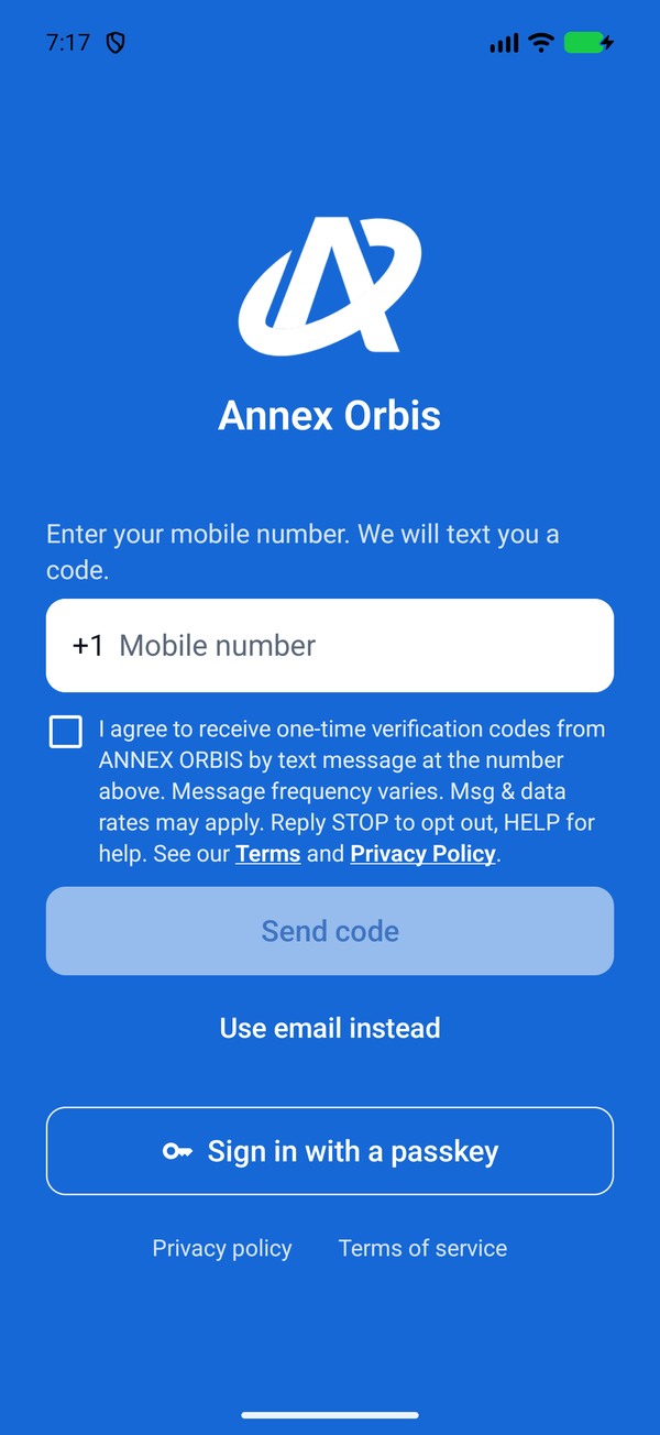 The ANNEX ORBIS app sign-in screen with the text consent checkbox unticked, Use email instead and Sign in with a passkey